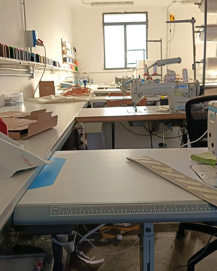 Produzione divani su misura: laboratorio di tappezzeria con macchine da cucire industriali