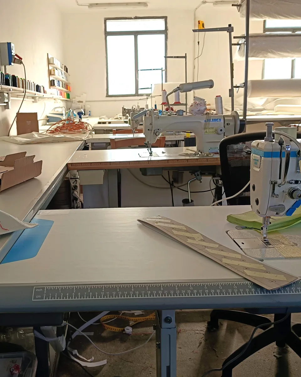Contatti Rive Design: laboratorio di tappezzeria a Sambruson di Dolo, con le macchine da cucire e il tavolo da taglio col righello