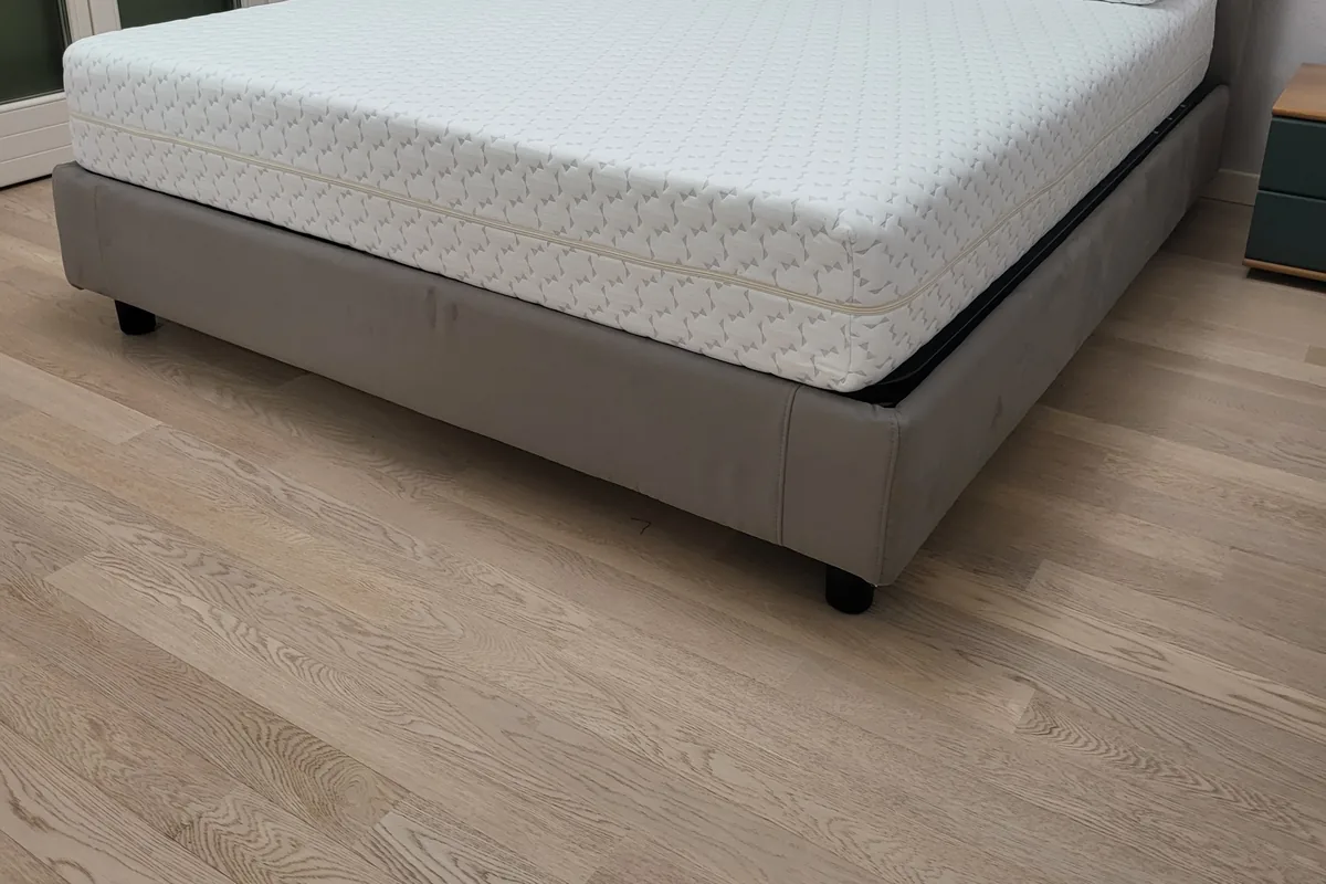 Letti e materassi su misura: letto grigio con materasso memory e due guanciali in camera con parquet