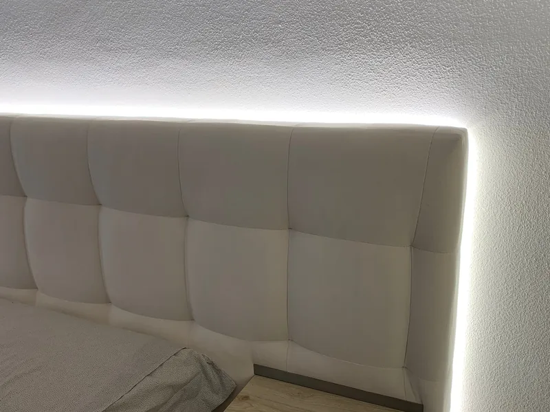 Letti su misura: testiera trapuntata con luce led perimetrale sulla parete