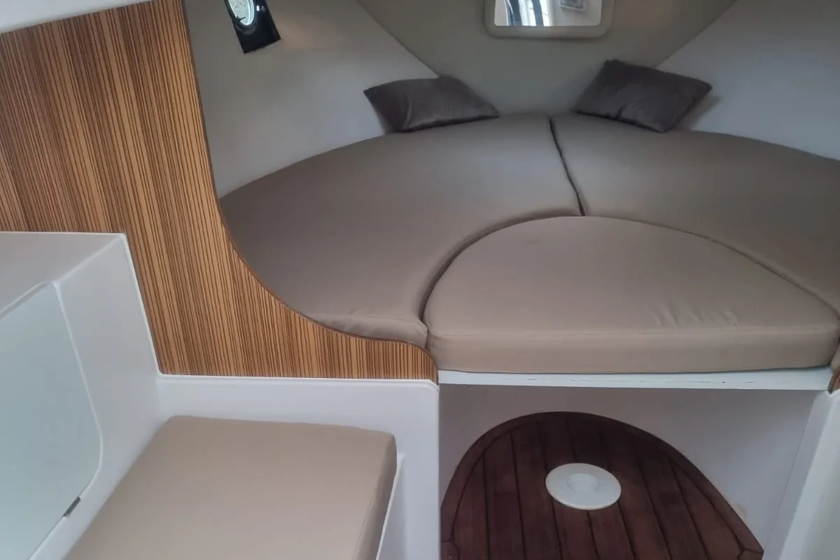 Materassi per barche: cabina di prua con materasso a V sagomato in tessuto beige e panca coordinata