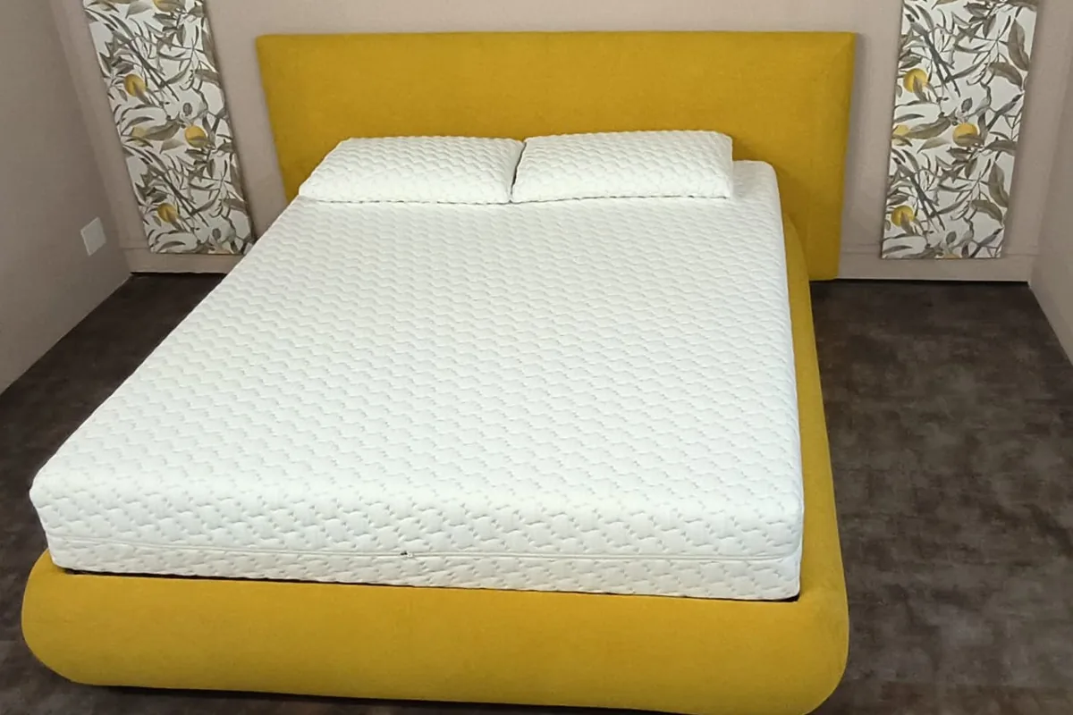 Materassi su misura: materasso memory trapuntato con due guanciali su letto giallo senape