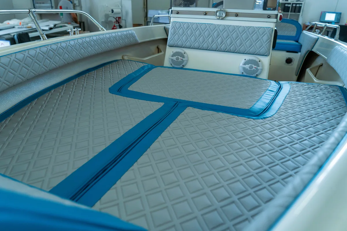 Tappezzeria nautica: prendisole di prua trapuntato a rombi grigio chiaro con bordature azzurre