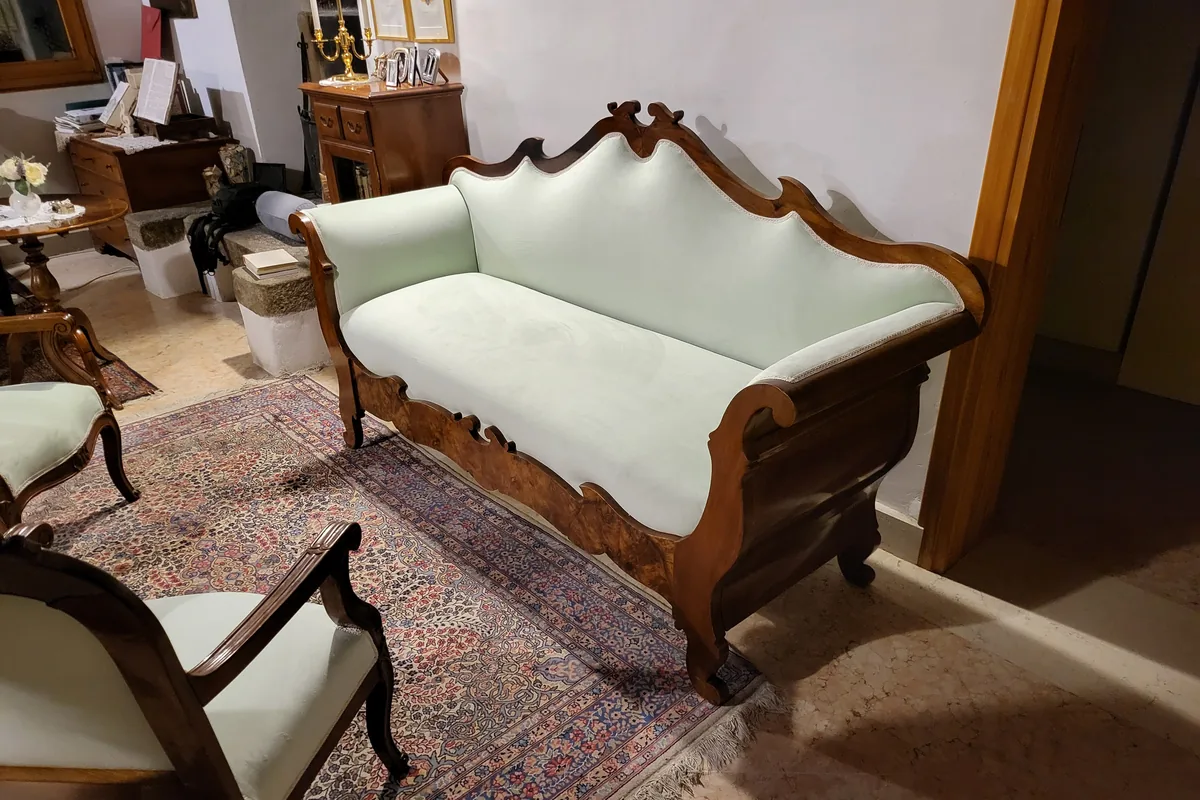 Restauro divani e poltrone: divano settecentesco in legno intagliato rivestito in tessuto chiaro, con la poltrona coordinata