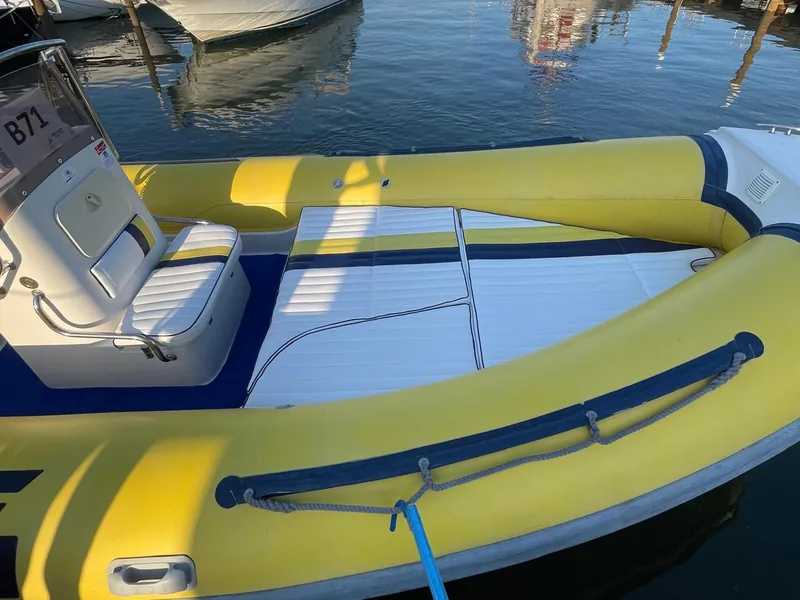 Rivestimenti per barche: gommone ormeggiato in porto con prendisole bianco, giallo e blu