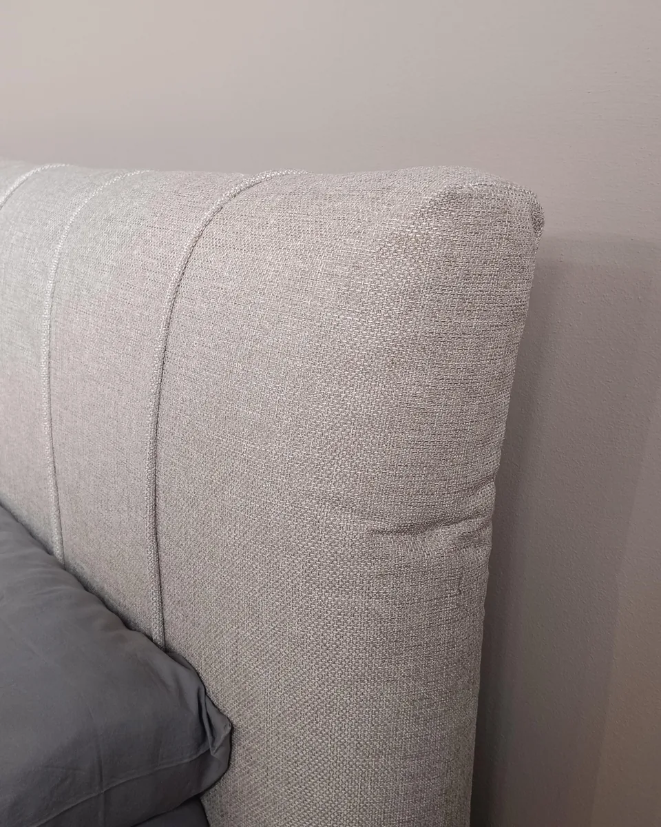 Il metodo Rive Design: testiera imbottita in tessuto chiaro con profili cuciti e tessuto ben teso