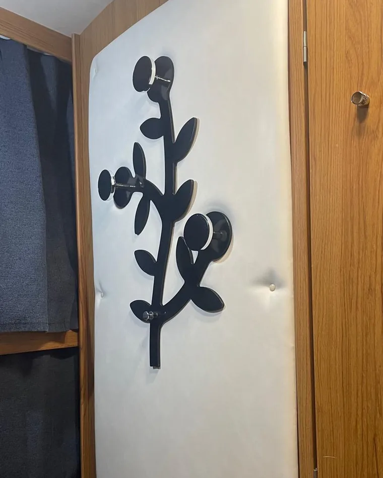 Tappezzeria su misura per camper: pannello imbottito bianco con bottoni e decoro nero a forma di ramo