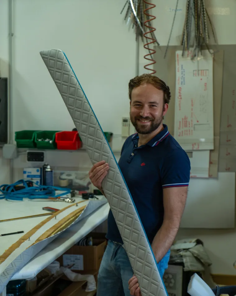Il metodo Rive Design: il tappezziere in laboratorio con una lunga fiancata trapuntata appena finita